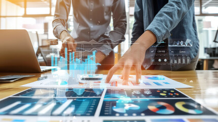 Two business professionals collaborate over paperwork, examining detailed reports with futuristic holographic data overlays.