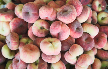 Ripe chinese flat peach fruits in a market.