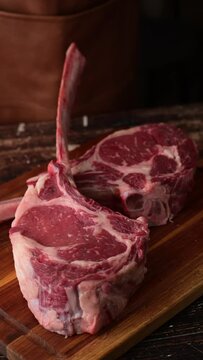 dropping tomahawk steak on cutting board 