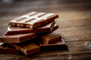 black and milk chocolate bars dark wooden table background