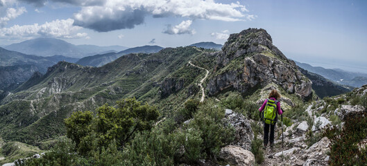 Hiker woman walking along the ridge of a mountain in the Sierra de Tejeda and Almijara.
