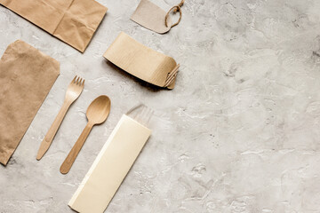 food delivery with paper bags and flatware on stone table background top view mockup