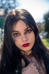 Naklejka premium Brunette woman with red lipstick posing outdoors