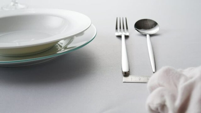 Fancy restaurant, waiter Elegant table setting with white square plate and silverware, arranged for sophisticated dining