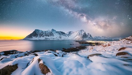  Milky Way above frozen sea coast and snow covered mountains in winter at night in Lofoten Islands, Norway. Arctic landscape with blue starry sky, water, ice, snowy rocks, milky way. Beautiful space.