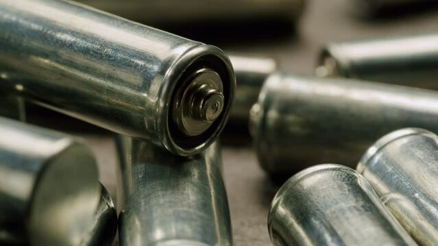 Silver batteries AA and AAA on black background close-up. Double-A battery is a standard size single cell cylindrical dry battery. Batteries are common in portable electronic devices. An AA battery is