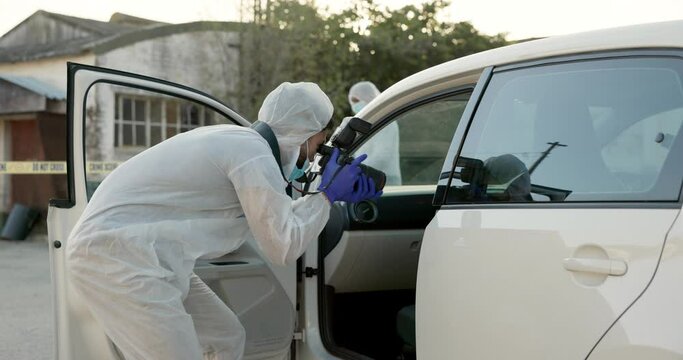 Forensic photographer, car and crime outdoor for inspection, hijacking and evidence for police. Man, camera and outside on road with investigation, accident and ppe suit by stolen vehicle in Sydney