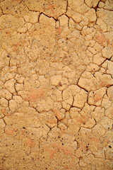 Wall of old mud house. Clay wall, surface texture. Close up. Vertical.