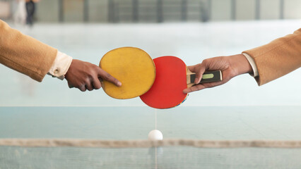 Two young male students play an energetic game of table tennis in a school setting, showcasing fun and activity.