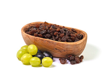 Getrocknete Weinbeeren in einer Holzschale vor weißem Hintergrund