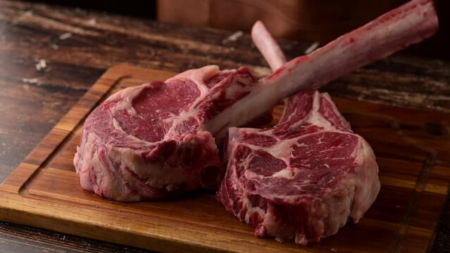 dropping tomahawk steak on cutting board 