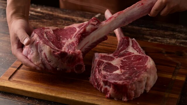 butcher placing  tomahawk steak on cutting board