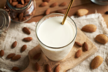 A glass of vegan almond milk on a table, with ecological stainless steel straw
