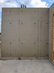 Architectural visual concrete finish mockup at construction site. Standalone concrete structure with visible formwork and smooth finish. Industrial construction and building design.