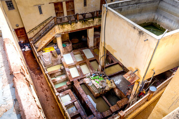 Fez, Morocco - March 18, 2024: The tannery in Fez. The dye industry in the city is considered one of the main tourist attractions. The tanneries are packed with the round stone wells filled with dye
