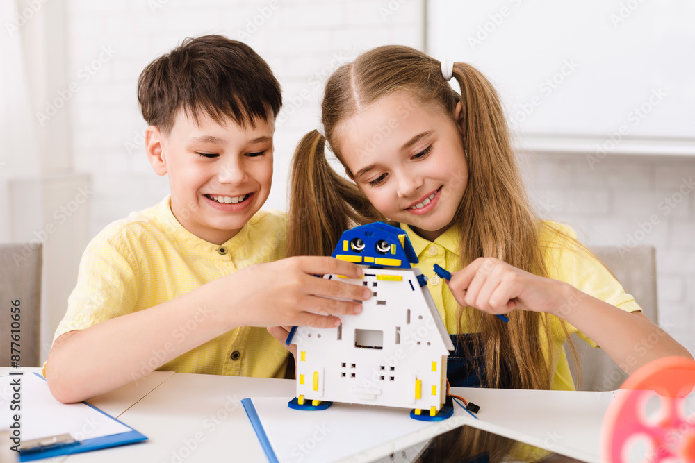 Poster two children, a boy and a girl, are working together to build a robot toy. they are both smiling and