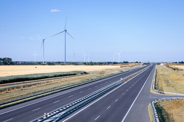 A highway with a windmill farm in the background.