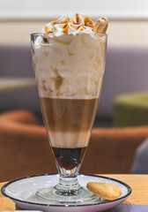 Caramel macchiato, frothed milk with caramel syrup with an espresso, under a generous cap of whipped cream topped with caramel cubes and caramel. Latte Macchiato is a coffee drink