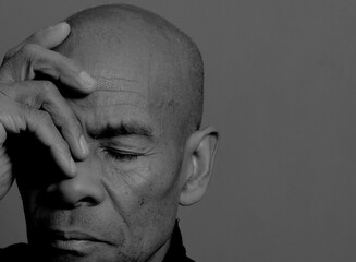 man praying to god with hands together Caribbean man praying with black background with people stock photo