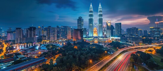 Obraz premium Kuala Lumpur skyline at night illuminated with lights. Modern cityscape view of Malaysia's capital city.