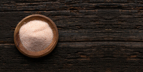 Fine Himalayan salt crystals in wooden bowl - Green background