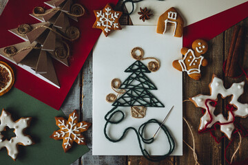 Cute handmade origami postcard from recycled paper with anise star on wooden background. Homemade gingerbread cookies. Holiday craft, family tradition, quality time., simple easy do it yourself decor