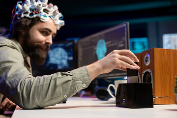 Engineer with EEG headset inserting cartridge into PC to use high tech software allowing for brain...