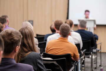 Group of attendees focused on a speaker at a tech conference. Ideal for concepts like learning, networking, and industry events.
