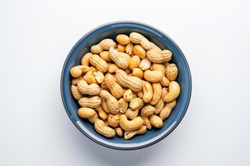 A bowl filled with peanuts sitting on a white surface