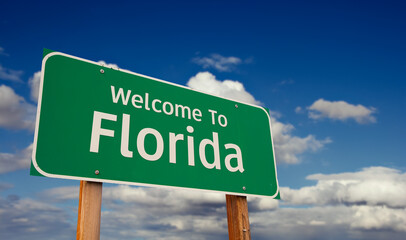 Welcome To Florida Green Road Sign Over Blue Sky with Some Clouds. © Andy Dean