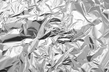 Crumpled silver foil as background, top view
