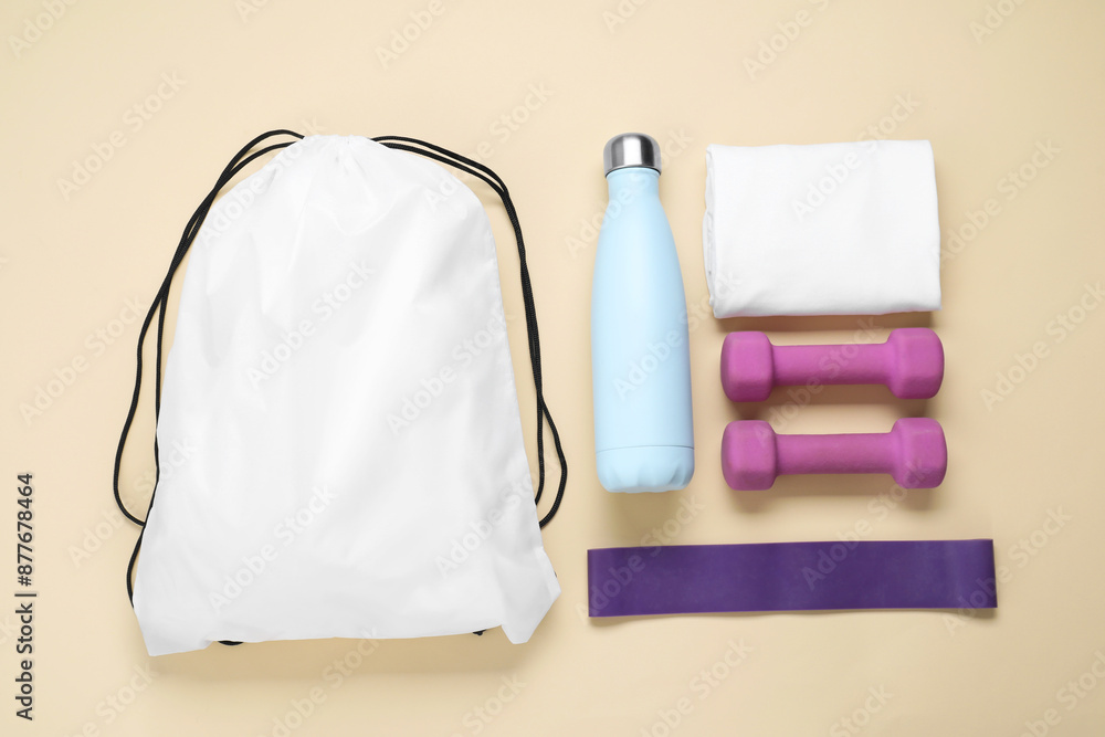 Poster White drawstring bag and sports equipment on beige background, flat lay