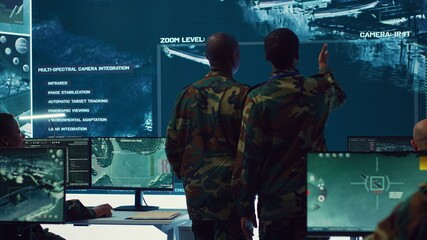 High ranking military personnel briefs the crew for a new federal mission, showing CCTV footage of...