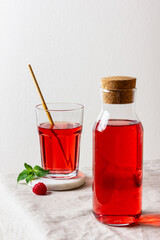 Raspberry drink in the glass on the light background.
