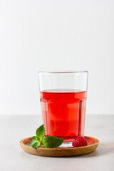 Raspberry drink in the glass on the light background.