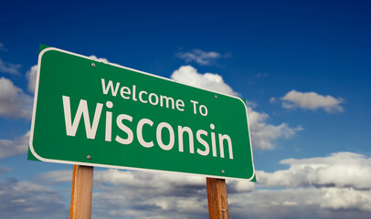 Welcome To Wisconsin Green Road Sign Over Blue Sky with Some Clouds. © Andy Dean