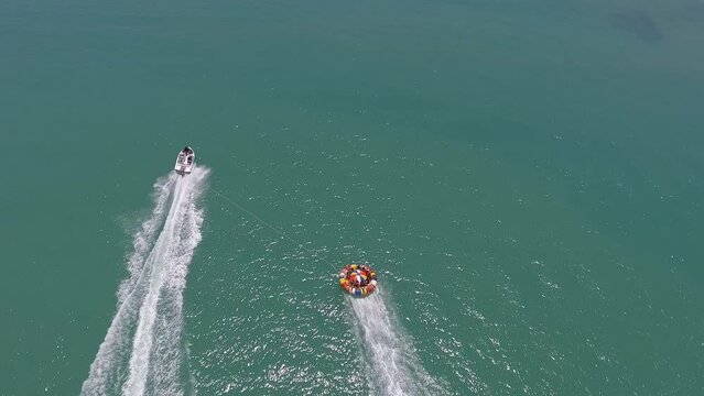 Speedboat tows buoy with tourists on Gunga Beach - Roteiro, Alagoas, Brazil