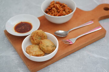perkedel, sweet and spicy dried tempeh and chili sauce on a cutting board