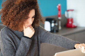 Curly-haired woman, deep thought, analyzing online information