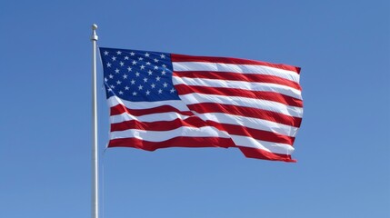 Obraz premium An image of the American flag flying high against a clear blue sky, representing national pride, freedom, and the enduring spirit of the United States.