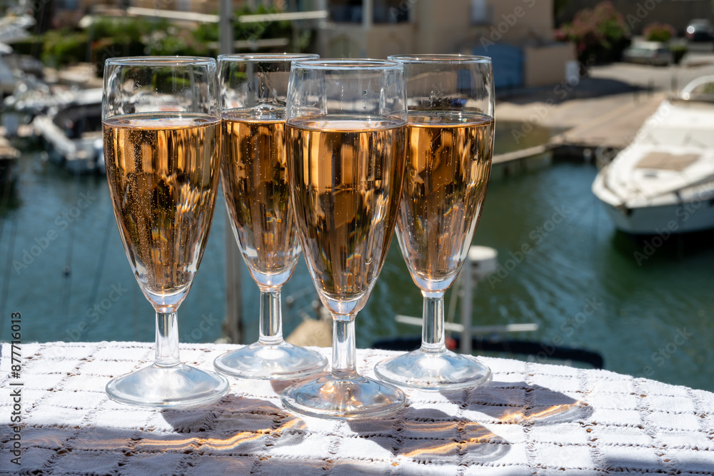 Wall mural summer party, french brut rose champagne sparkling wine in flute glasses in yacht harbour of port gr