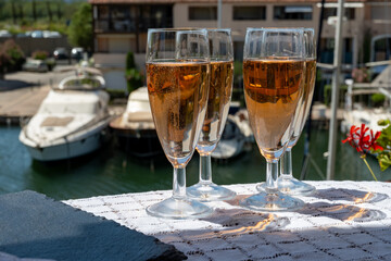 Summer party, French brut rose champagne sparkling wine in flute glasses in yacht harbour of Port Grimaud near Saint-Tropez, French Riviera vacation, Var, France