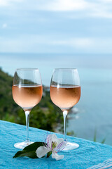 Summer time in Provence, two glasses of cold rose wine with blue sea view on background, French Riviera near Menton, south of France