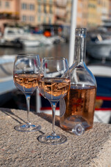 Glasses of cold rose Cote de Provence wine in old fisherman boats and yacht harbour in Saint-Tropez, summer vacation on French Riviera in Provence, France