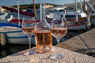 Glasses of cold rose Cote de Provence wine in old fisherman boats and yacht harbour in Saint-Tropez, summer vacation on French Riviera in Provence, France