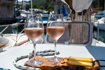 Party with rose wine on yacht boat anchored in port la Rague, Gulf of La Napoule, in Provence, two glasses of cold rose wine, French Riviera near Cannes, south of France