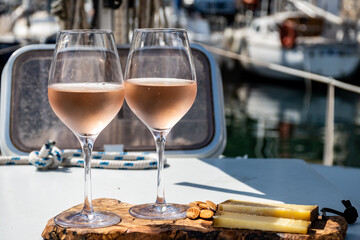 Party with rose wine on yacht boat anchored in port la Rague, Gulf of La Napoule, in Provence, two...
