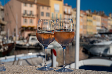 Glasses of cold rose Cote de Provence wine in old fisherman boats and yacht harbour in Saint-Tropez, summer vacation on French Riviera in Provence, France