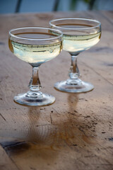 Sparkling wine, cava or champagne in two coupe glasses on wooden table, French Riviera is summer, France
