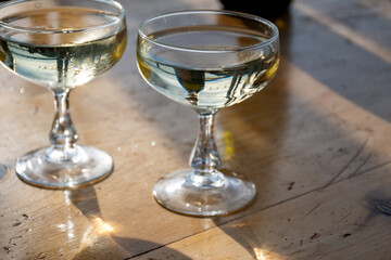 Sparkling wine, cava or champagne in two coupe glasses on wooden table, French Riviera is summer, France
